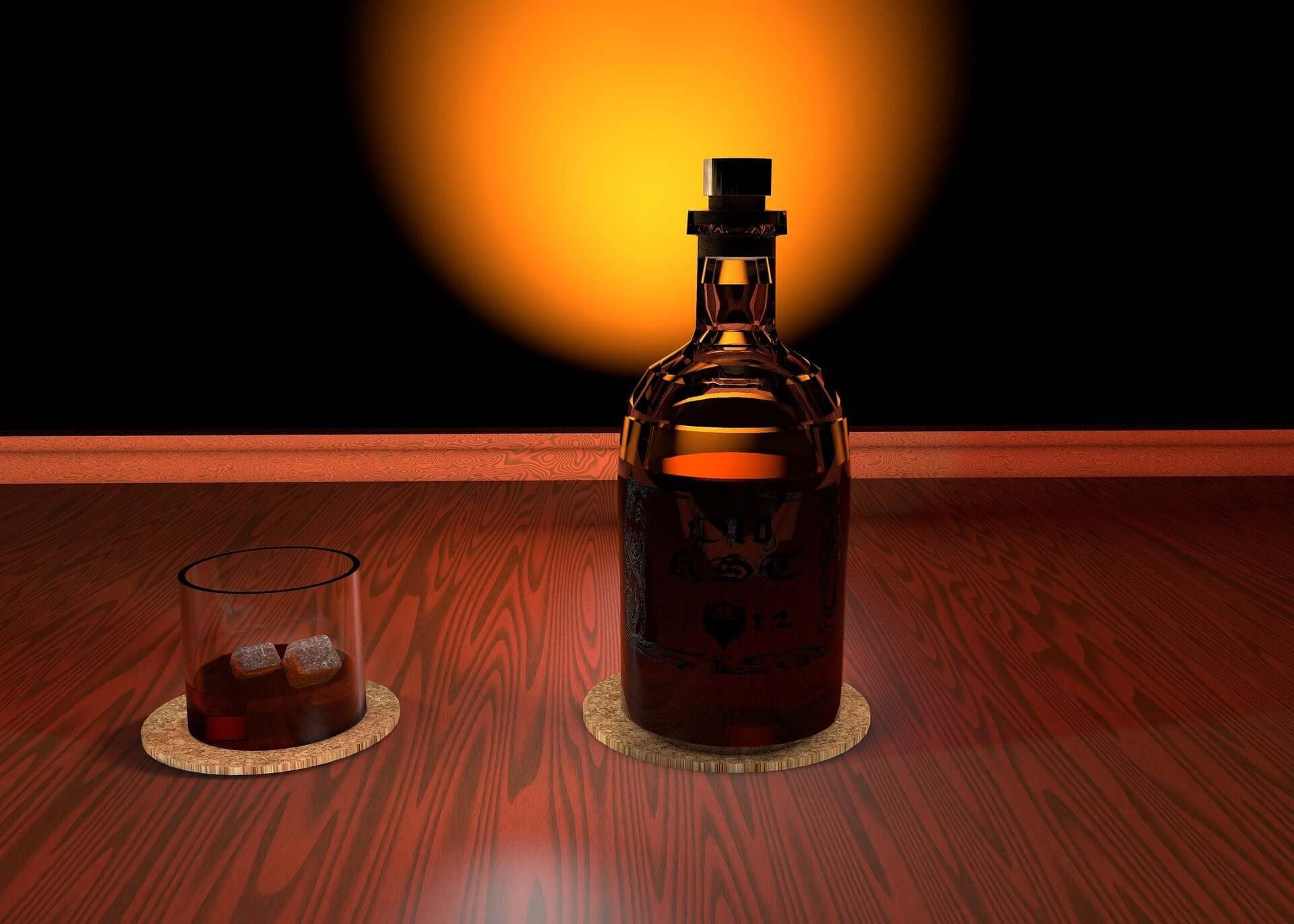 A bottle of bourbon alongside a glass rests on a table, creating a sophisticated atmosphere with subtle lighting.